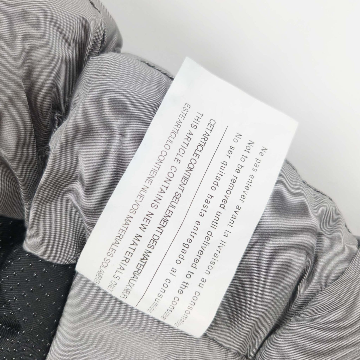 A metallic grey 7AM Enfant stroller blanket label