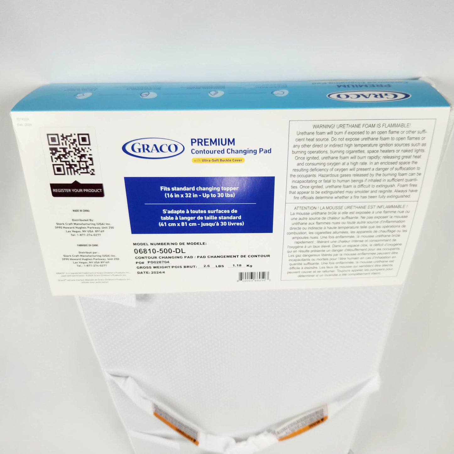 Graco Premium Contoured Changing Pad in white, with a visible blue and white packaging back side