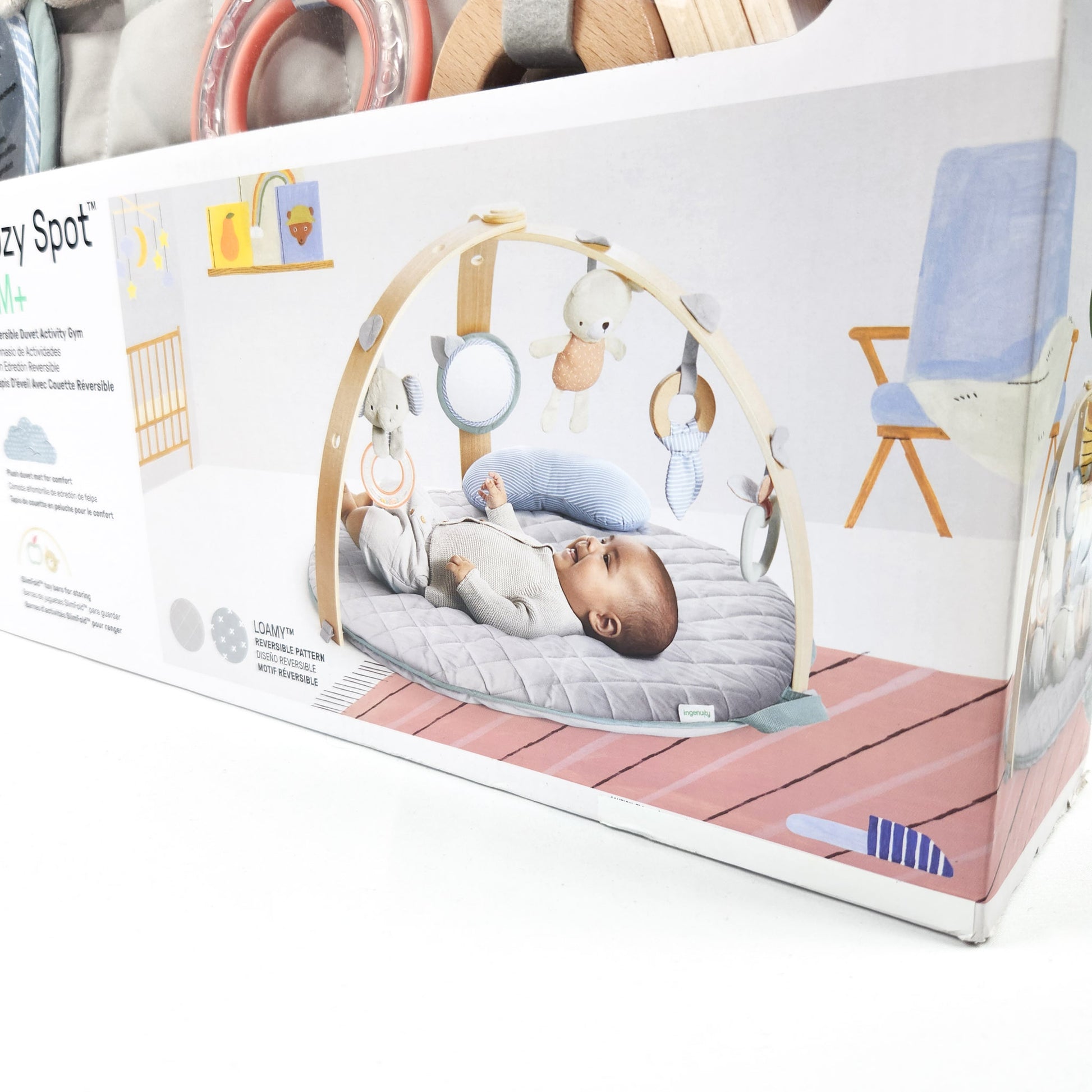 Ingenuity Cozy Spot reversible duvet activity gym in box showing picture of a baby playing on the mat with hanging toys
