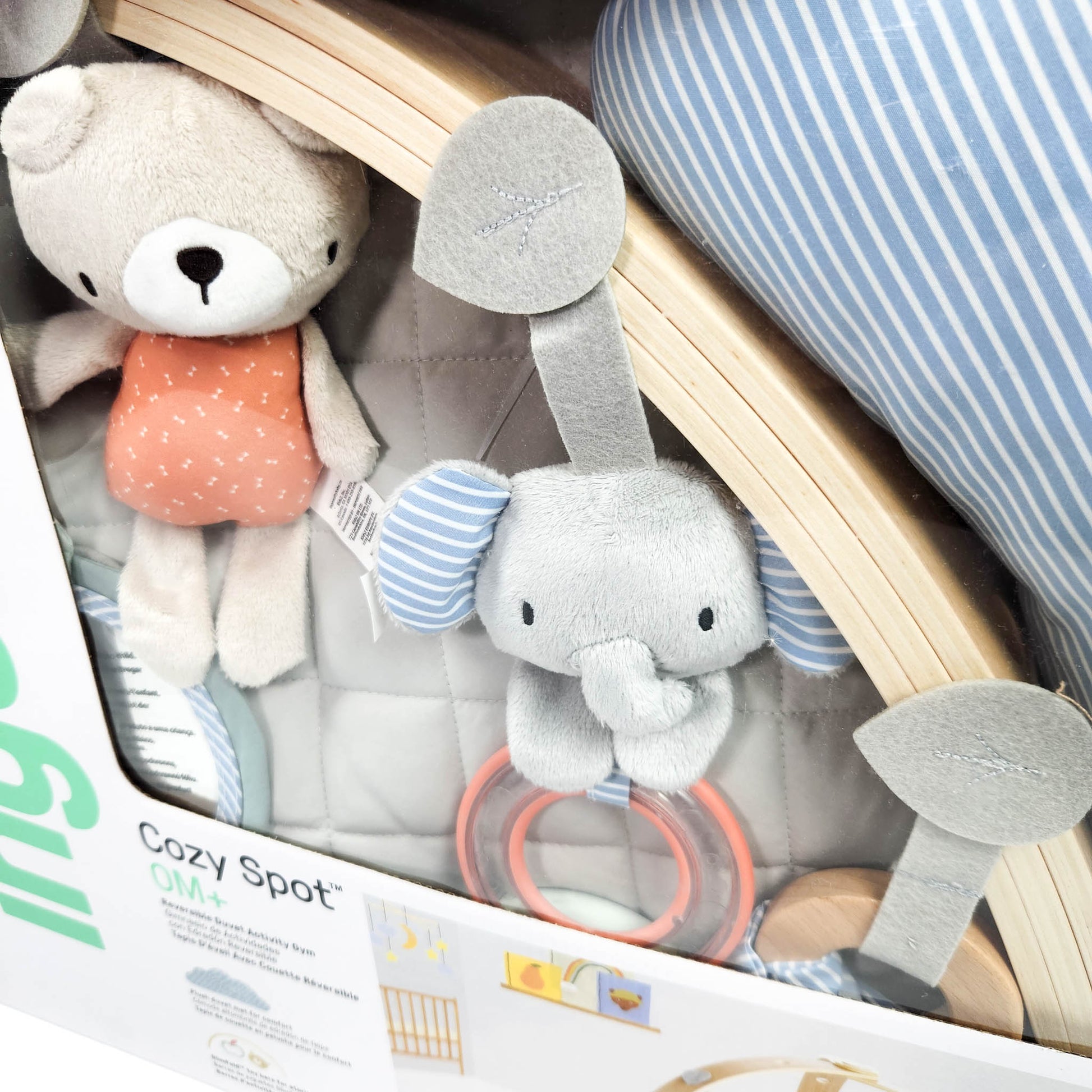 Ingenuity Cozy Spot reversible duvet activity gym in box showing play mat and hanging toys close up
