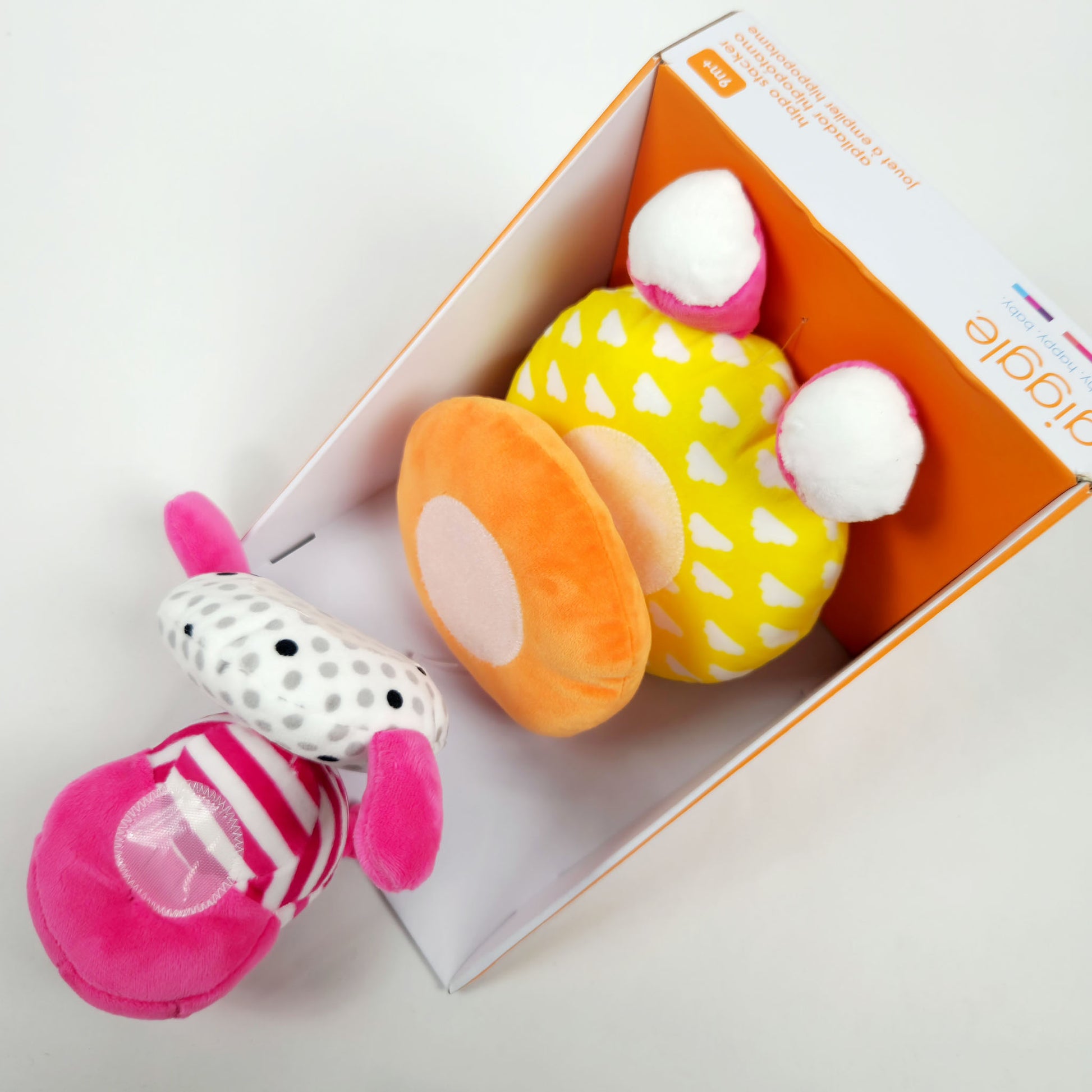 Giggle soft stacker baby toy pink hippo plush with colorful stacking rings in packaging showing close up detail